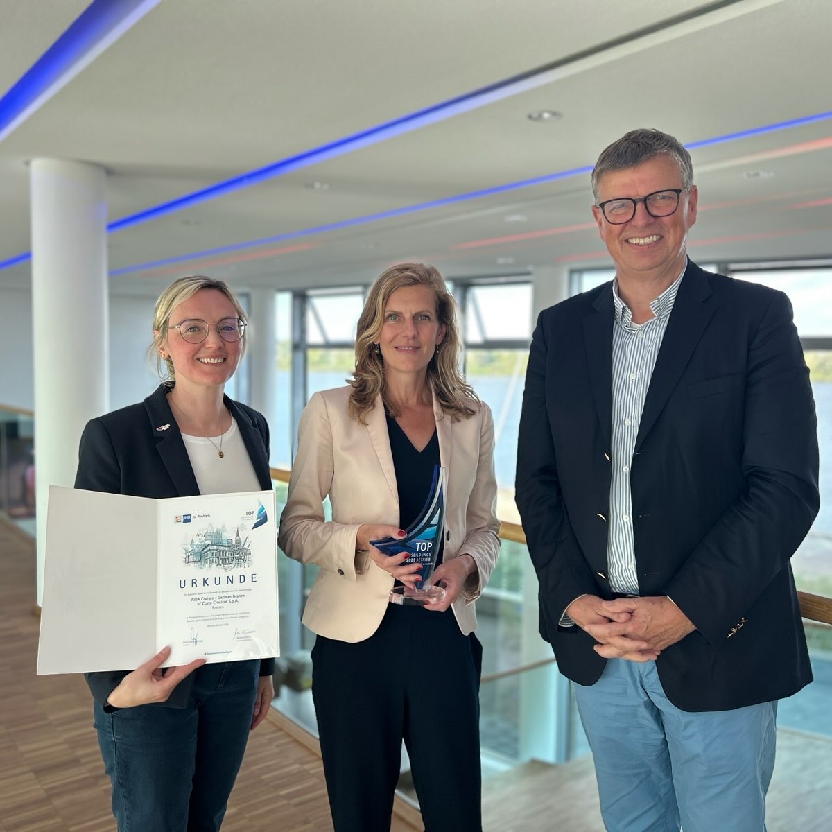 Ein Mann und drei Frauen halten Pokal und Urkunde zum TOP Ausbildungsbetrieb