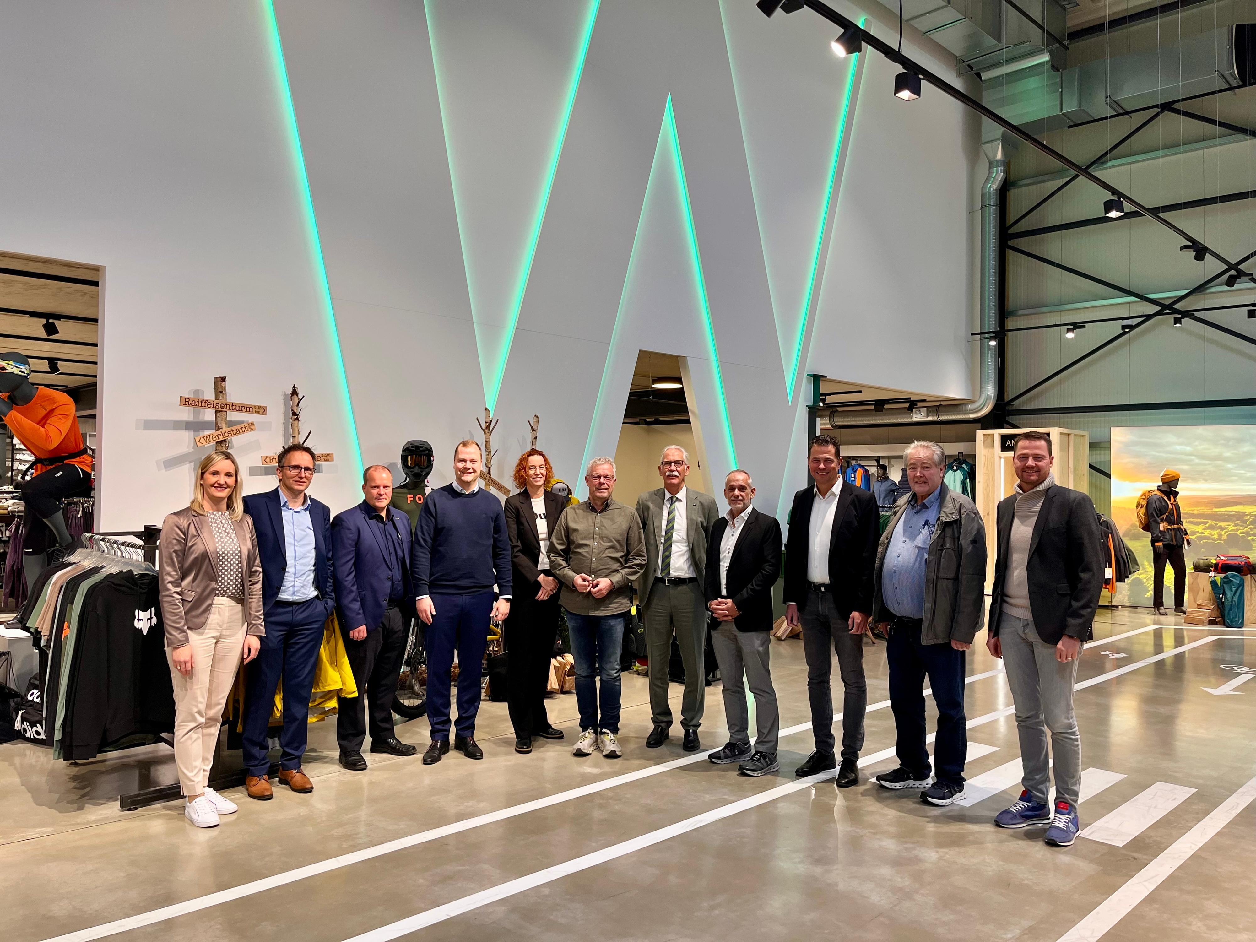 Gruppenbild Beiratssitzung 2024 - 2 Damen und 9 Herren stehen in einem Verkaufsraum