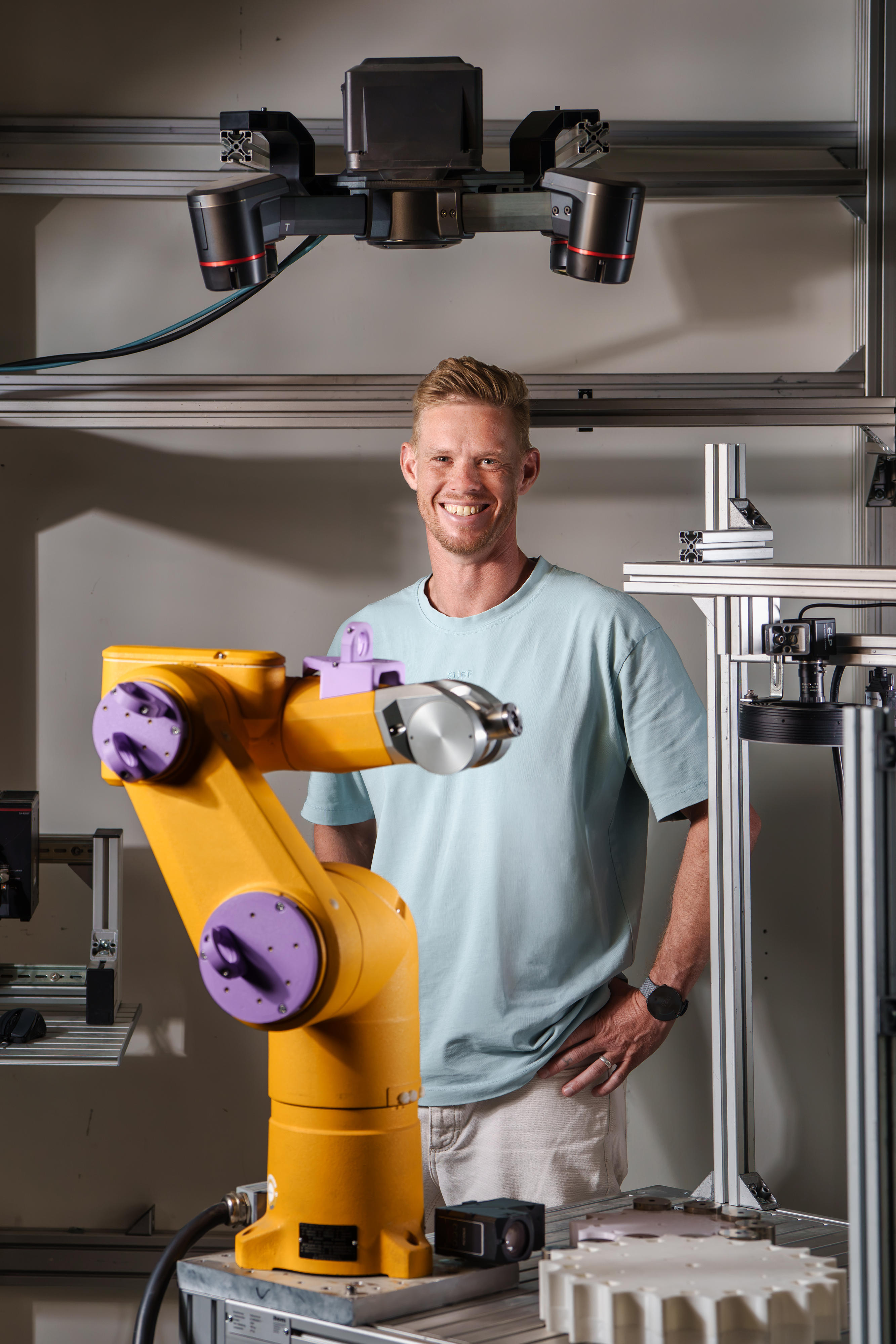 Jasper Rauns steht hinter einem Roboter.