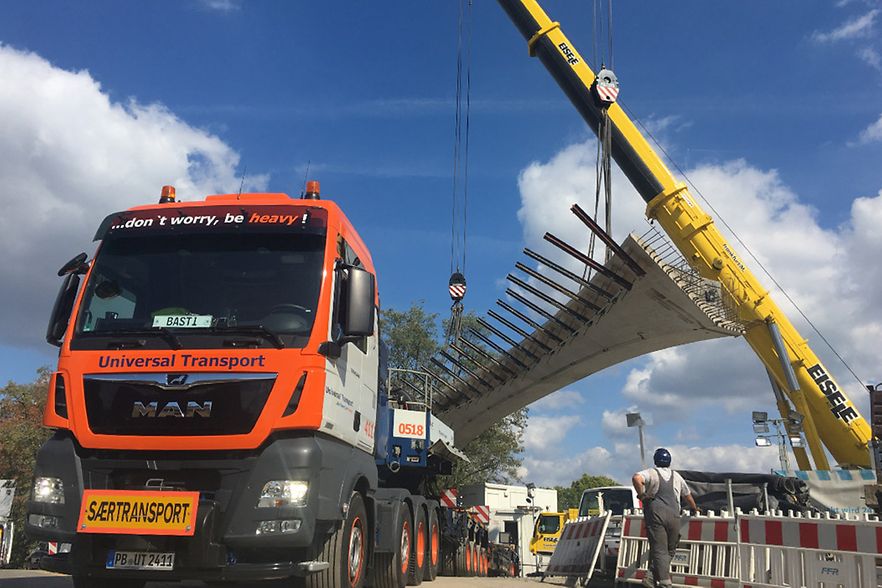 LKW der mit einem Br&uuml;ckenteil beladen wird