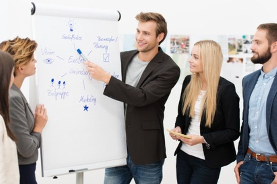 Junge Menschen stellen eine Pr&auml;sentation zum Thema Existenzgr&uuml;ndung am Flipchart vor