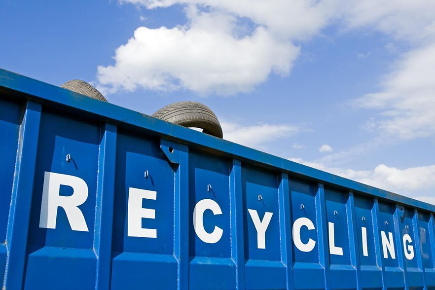 blauer Recycling Container aus dem Autoreifen raus schauen mit wei&szlig;er Aufschrift RECYCLING