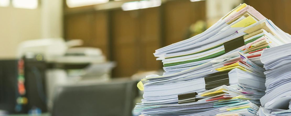 Stapel von Dokumenten auf dem Schreibtisch am Arbeitsplatz