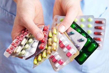 Eine Frau h&auml;lt viele Blister mit Tabletten in den H&auml;nden