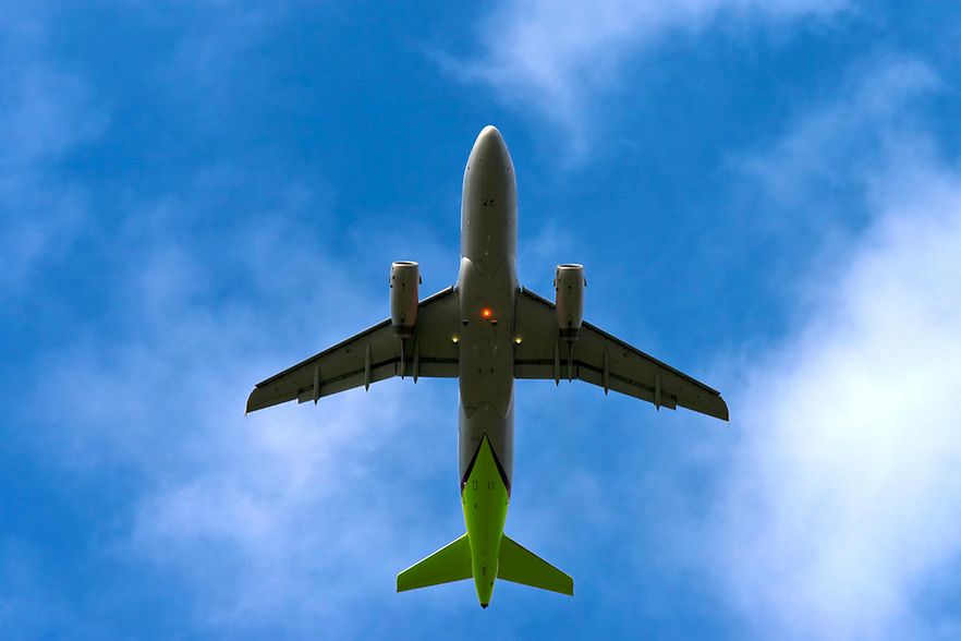 Flugzeug im blauen Himmel, Vollansicht von unten