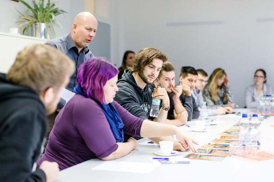 Auszubildende sitzen am Tisch w&auml;hrend eines Workshops