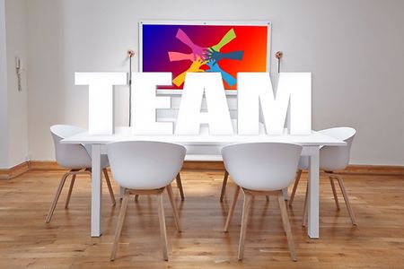St&uuml;hle an einem Tisch, darauf stehend die Buchstaben TEAM