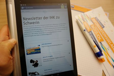 Hand h&auml;lt Tablet, Bildschirm Website mit Newsletter-Angebot