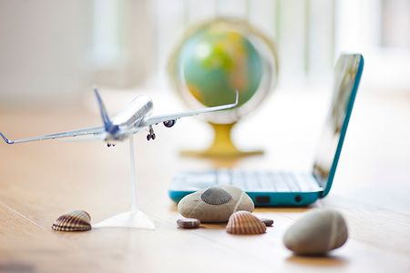 Modell eines Flugzeugs vor einem Globus und Laptop