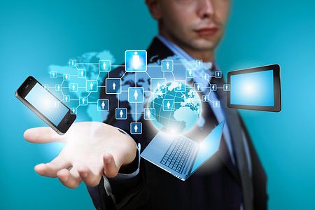 Ein Gesch&auml;ftsmann mit Smartphone Laptop und Tablet 
