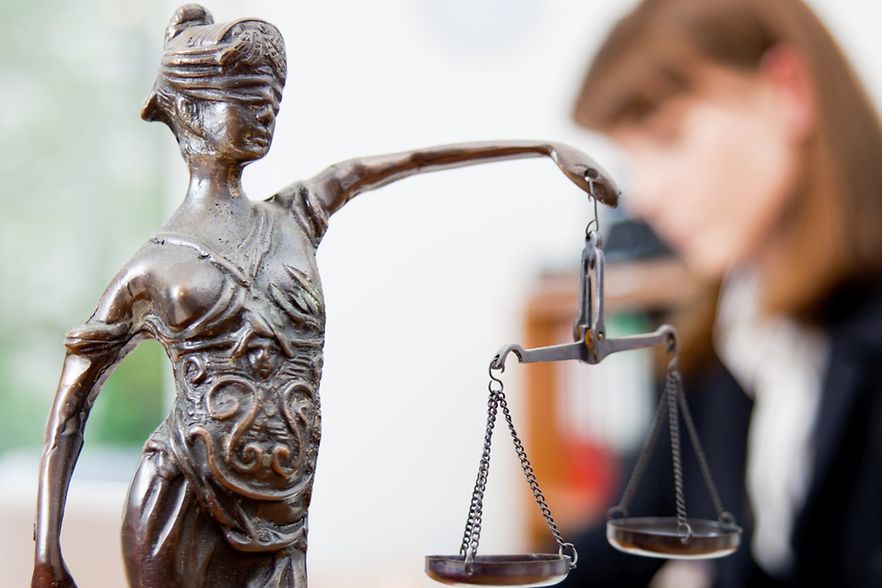 Das Bild zeigt eine Statue einer Frau mit verbundenen Augen. Sie h&auml;lt eine Waage aufrecht vor sich.