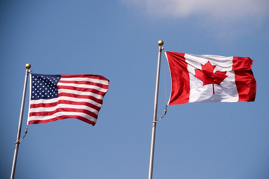 Flagge USA und Flagge Kanada wehen im Wind