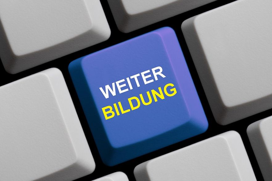 Das Bild zeigt eine Tastatur. Eine Taste ist Blau und hat den Schriftzug Weiterbildung.
