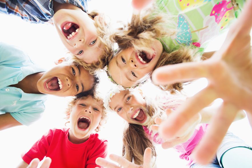 Lachende Kinderk&ouml;pfe im Kreis angeordnet