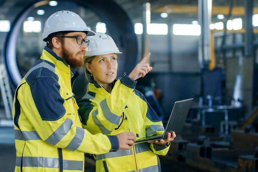 Zwei Industriemeister im Betrieb, die sich &uuml;ber ein technisches Problem austauschen.