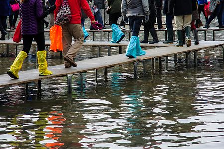 Hochwassersteg mit Menschen in Gummistiefeln