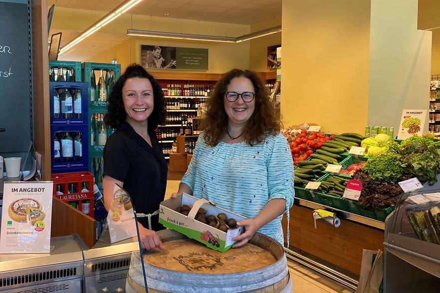 2 Frauen stehen in einem Laden und l&auml;cheln in die Kamera