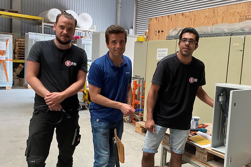 Drei M&auml;nner in Arbeitskleidung