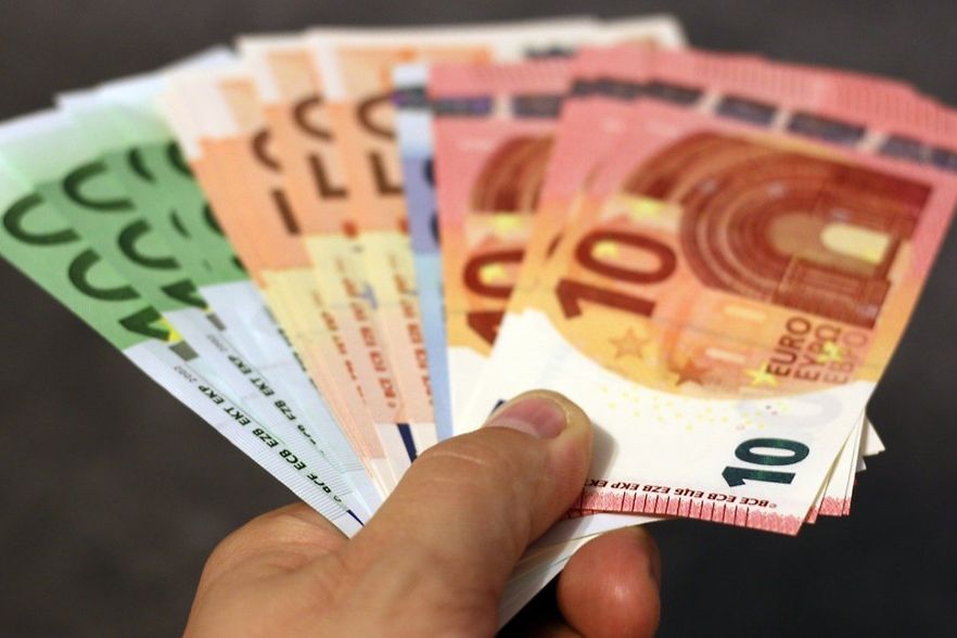 Euro-Geldscheine in einer Hand haltend