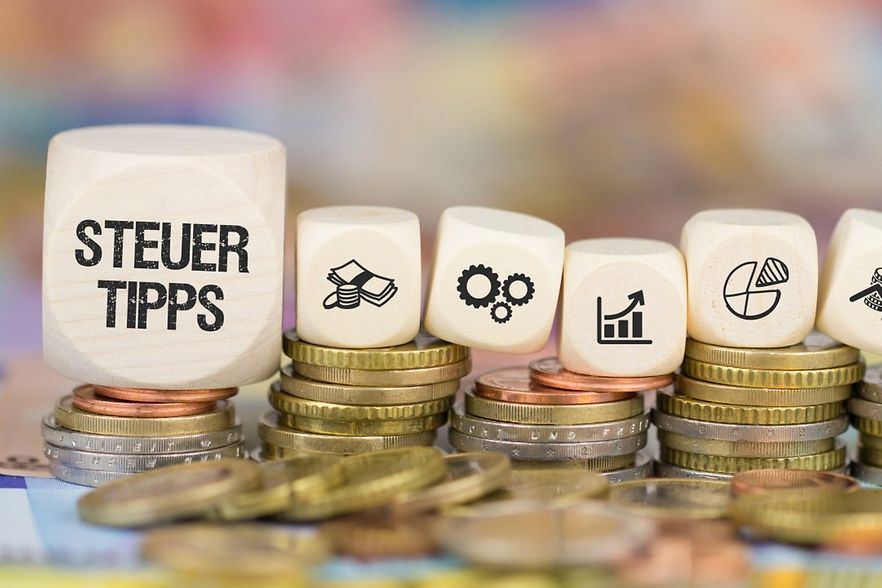 Stapel mit Geldm&uuml;nzen, Aufschrift Steuertipps und grafische Symbole