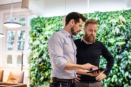 Businessman discussing with colleague over digital tablet in office