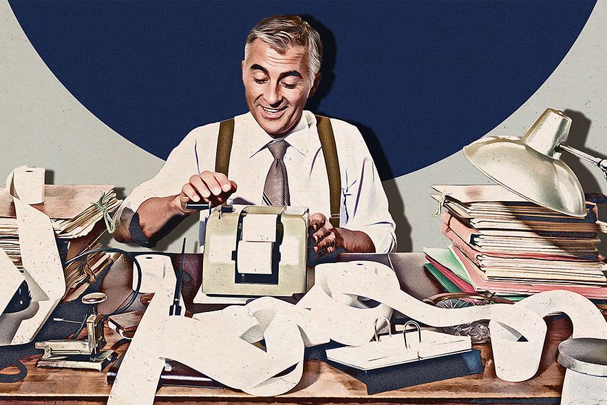 Mann sitzt vor Rechenmaschine