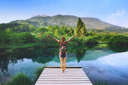 junge Frau im Urlaub auf einem Steeg am See