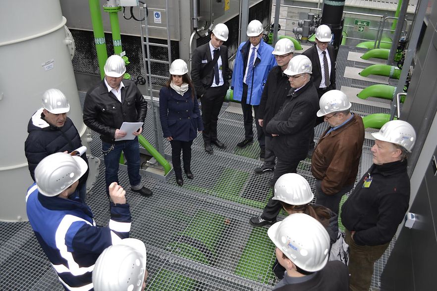 Gruppe von Personen mit Helm in einer Industrieanlage
