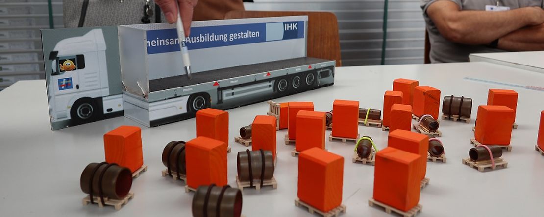 Spielzeug-LKW und kleine orangene Kl&ouml;tze und weiteres Material als Anschauungsmaterial f&uuml;r Pr&uuml;fung