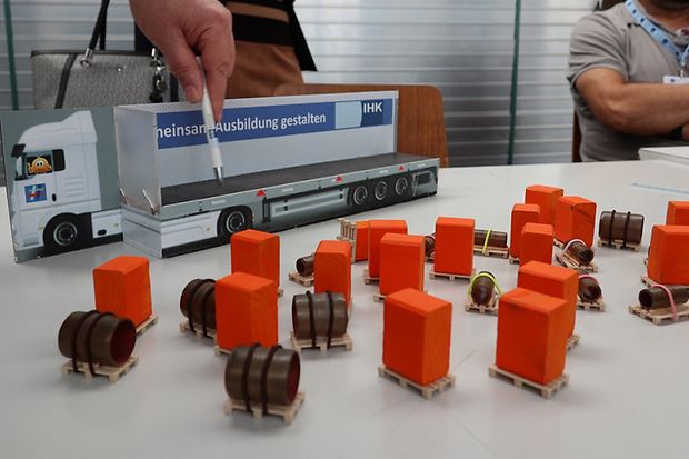 Spielzeug-LKW und kleine orangene Kl&ouml;tze und weiteres Material als Anschauungsmaterial f&uuml;r Pr&uuml;fung