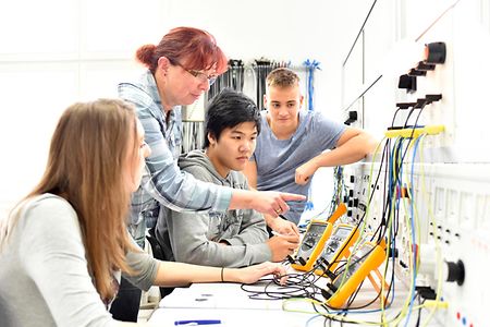 Ausbilderin erkl&auml;rt den Auszubildenen die Teile einer elektronischen Schaltung