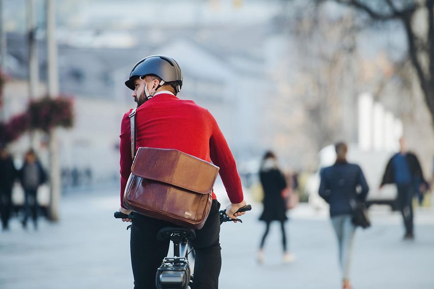 Ein Mann in einem roten Pullover auf einem Fahrrad. 