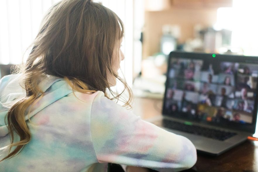 Kind vor Laptop mit virtueller Veranstaltung