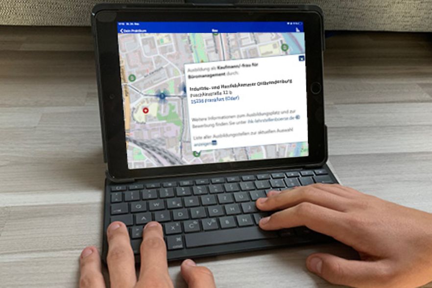 H&auml;nde bedienen IHK-Ausbildungsatlas auf dem Tuchscreen eines Tablett-Computer.