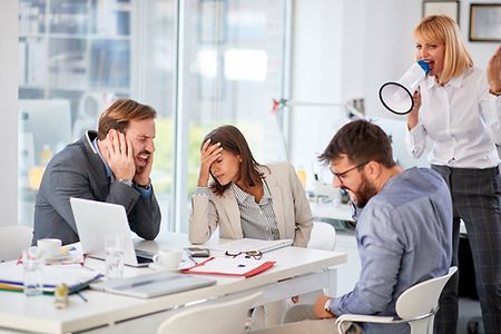 Hrau schreit mit Mikrofon Mitarbeiter an