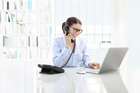 Frau an Telefon und Laptop
