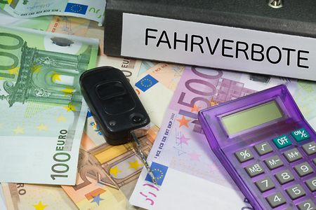 Geldscheine, darauf liegen Schl&uuml;ssel, Taschenrechner, Ordner mit Aufschrift "Fahrverbote"