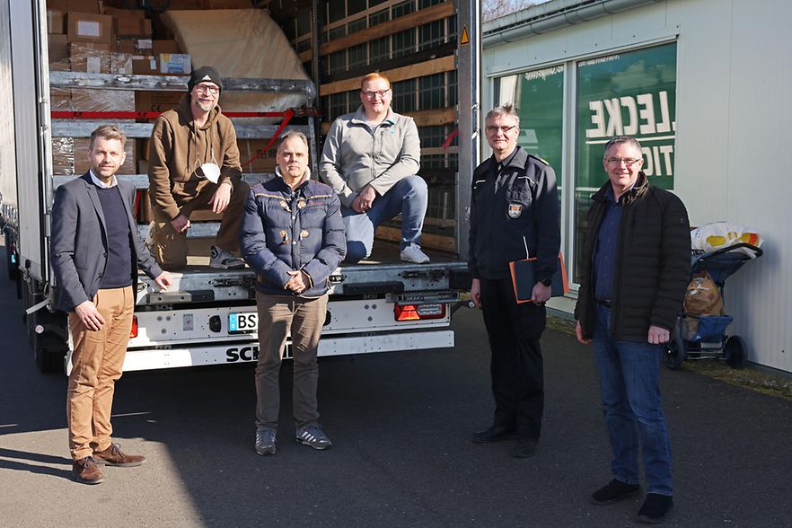 in der Ladefl&auml;che eines ge&ouml;ffneten Lkw. Im Hintergrund sind verpackte Kartons zu sehen.