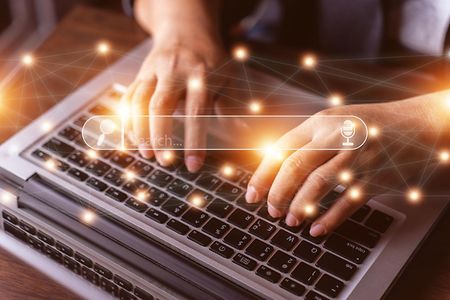 Laptop mit Suchmaschineneingabe im Vordergrund