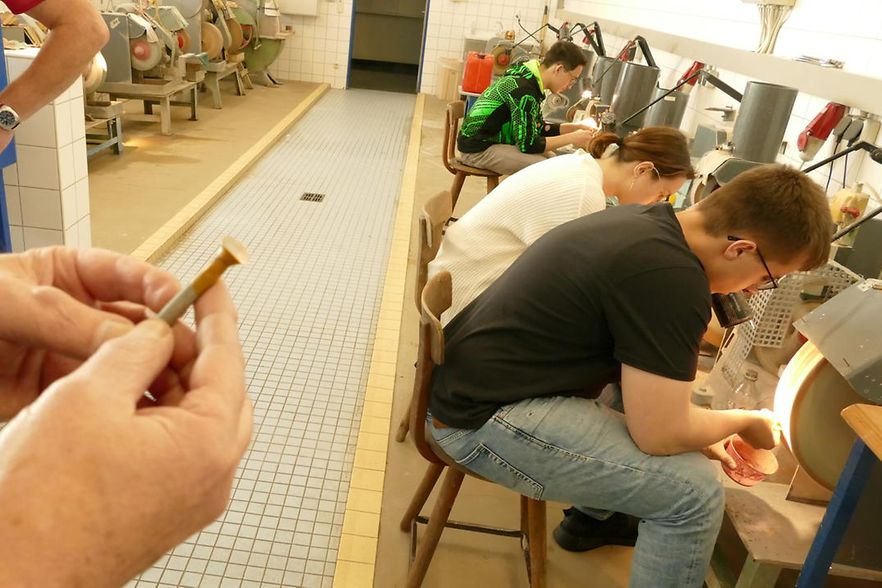 3 Azubis sitzen an Schleifsteinen