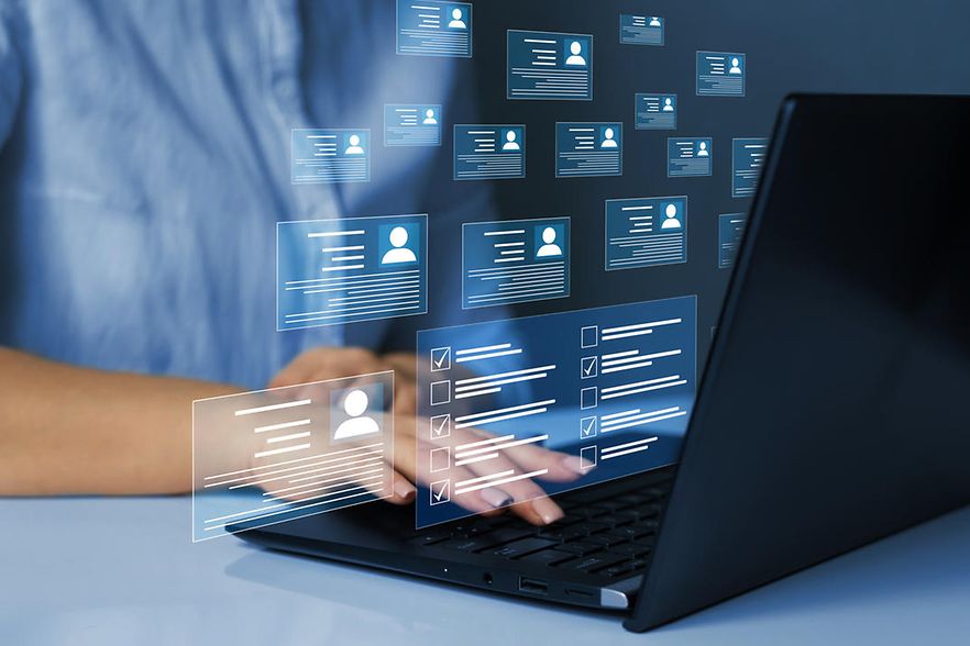 Person sitzt an einem Laptop, dazu Illustrationen von e-Visitenkarten