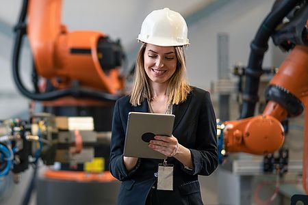 Female chief engineer in modern industrial factory using tablet and making audit.