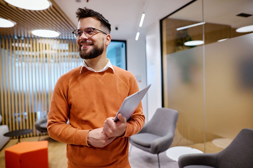 Ein Mann steht mit Unterlagen in einem B&uuml;ro