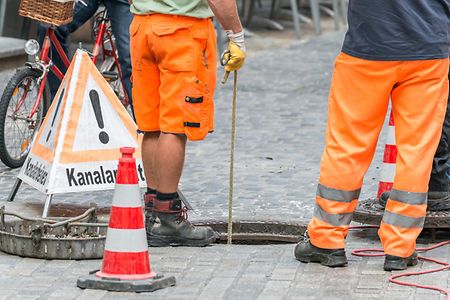 Kanalarbeiten von Bauarbeitern auf der Stra&szlig;e