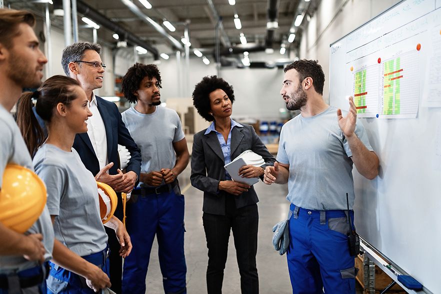 Arbeiter zeigt seinen Kollegen einen Plan