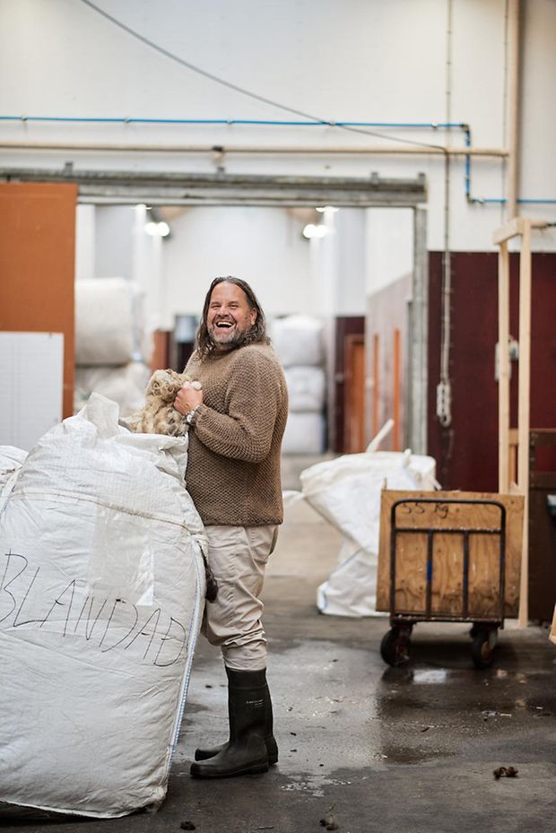 Francesco Mazuhn in der Lagerhalle mit einem Sack Wolle