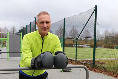 Patrick mit Boxhandschuhen auf einem Sportplatz