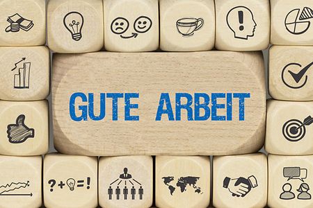 Das Bild zeigt W&uuml;rfel mit Symbolen und einen gro&szlig;en W&uuml;rfel mit dem Schriftzug gute Arbeit