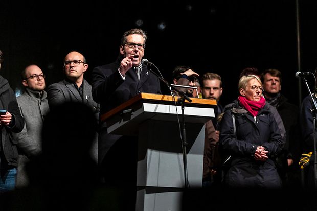 IHK-Präsident Martiné am Rednerpult, im Hintergrund weitere Redner*innen und die Organisator*innen