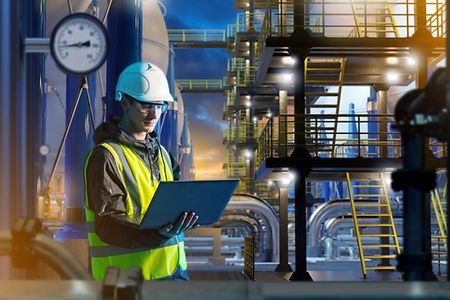Man works for energy company. Engineer stands among hydrogen equipment.